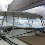 View from a boat looking out over calm water and distant hills under a cloudy sky.