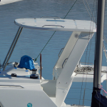 Close-up of a yacht's deck and radar arch on calm waters.