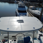 View from a boat's helm overlooking docked boats and calm water.
