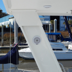 Close-up of a white structural support on a boat with a marina backdrop.