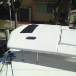 White boat canopy with solar panels and a small window.
