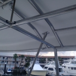 Boat canopy frame under construction with marina background.