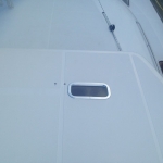 A close-up of a boat deck with a small rectangular window.