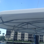 View of a boat canopy with buildings and blue sky in the background.