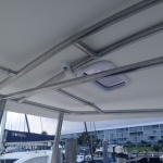 Boat canopy with metal frame and marina in the background.