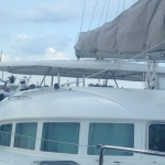 View from a boat deck looking forward under a partly cloudy sky.