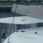 Close-up of a sailboat deck with rigging and a covered sail.
