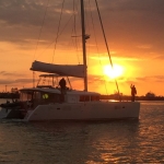 Sailboat gliding on water during a vibrant sunset.