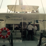 People preparing to sail on a boat during sunset.