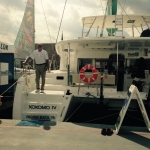 A man standing on a dock next to a boat named Kokomo IV.