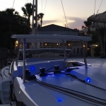 Sailboat deck illuminated with blue LED lights at dusk.