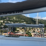 View of a coastal town with hills and boats under a boat canopy.