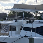 A white yacht docked at a marina under cloudy skies.