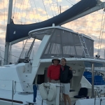 Couple posing on a boat deck during sunset.