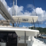 Sailboat docked under a blue sky with clouds.