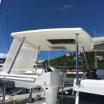 A white boat canopy providing shade on a sunny day at the marina.