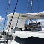 Close-up of a white yacht with sails and rigging under a blue sky.