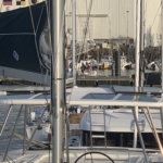 Sailboats docked at a marina on a calm day.