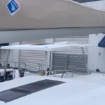 Sailboat deck with rigging and safety equipment visible.