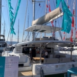 A sleek catamaran docked at a marina under clear skies.