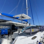 A sleek white yacht docked under a clear blue sky with solar panels on its roof.