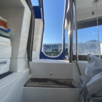 View from inside a boat cabin looking out a window at the marina.