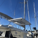 Sailboat docked at a marina under a clear blue sky.