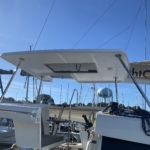 Sailboat deck with a large canopy and clear blue sky.
